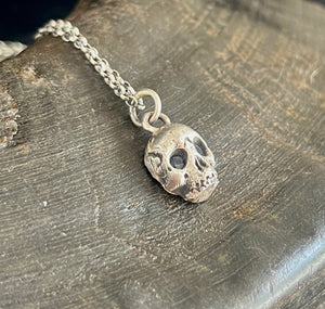 Sterling silver skull with 2 blue sapphire eyes.