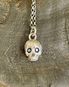 Sterling silver skull with 2 blue sapphire eyes.