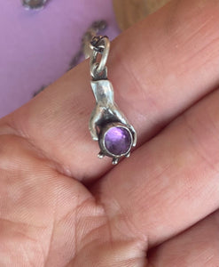 Hand pendant holding a faceted amethyst. Sterling silver handmade stone set pendant.