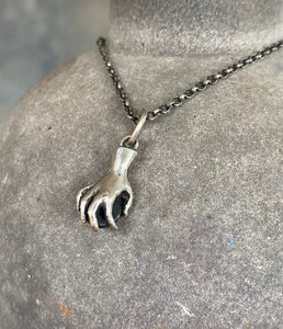 Hand pendant holding a faceted amethyst. Sterling silver handmade stone set pendant.